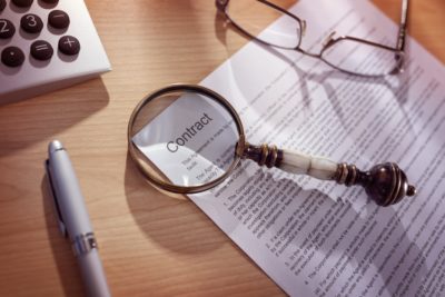 Attorney Referral Magnifying glass on a legal contract