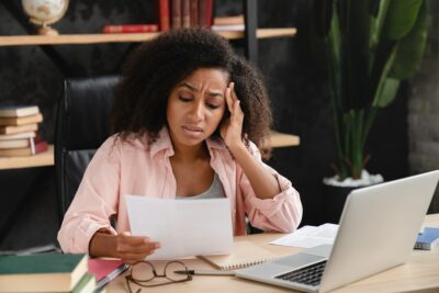 Sad exhausted depressed tired woman reading document with debt on timeshare