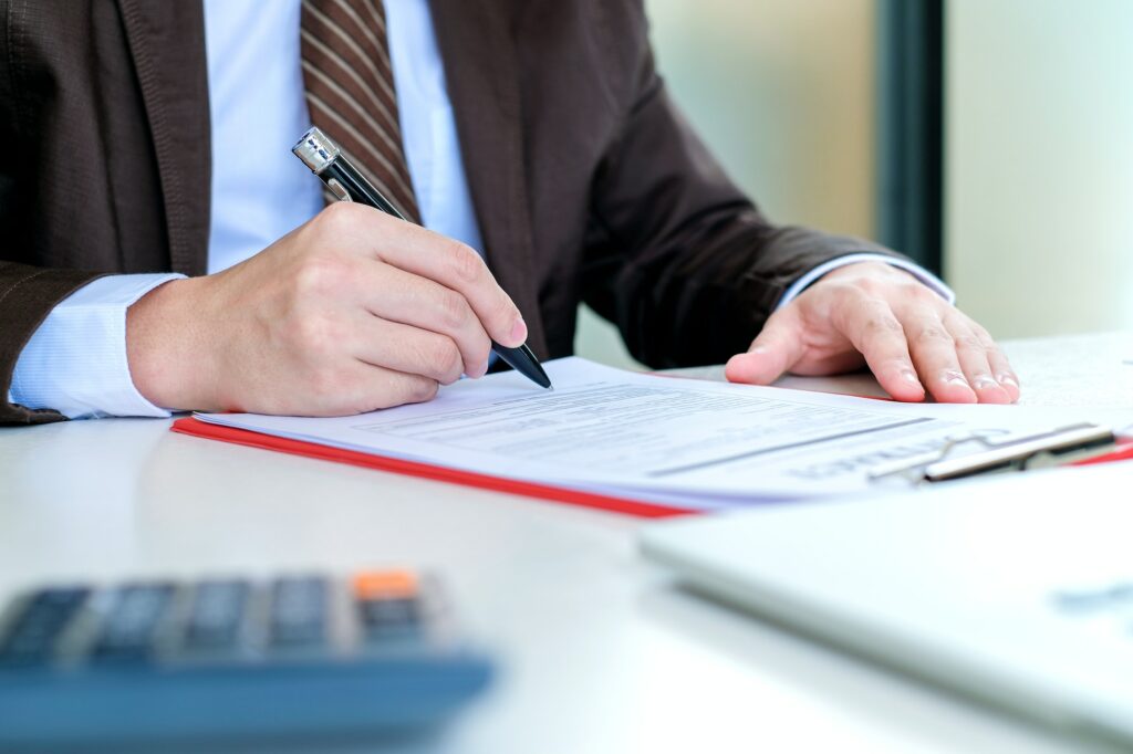 Man signing a non-reliance clause in a contract.