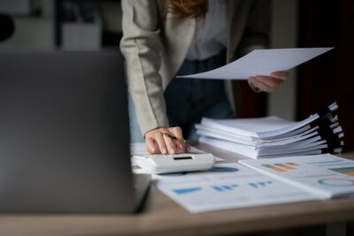 Close up accountant banker or bookkeeper making credit score calculations with calculator.